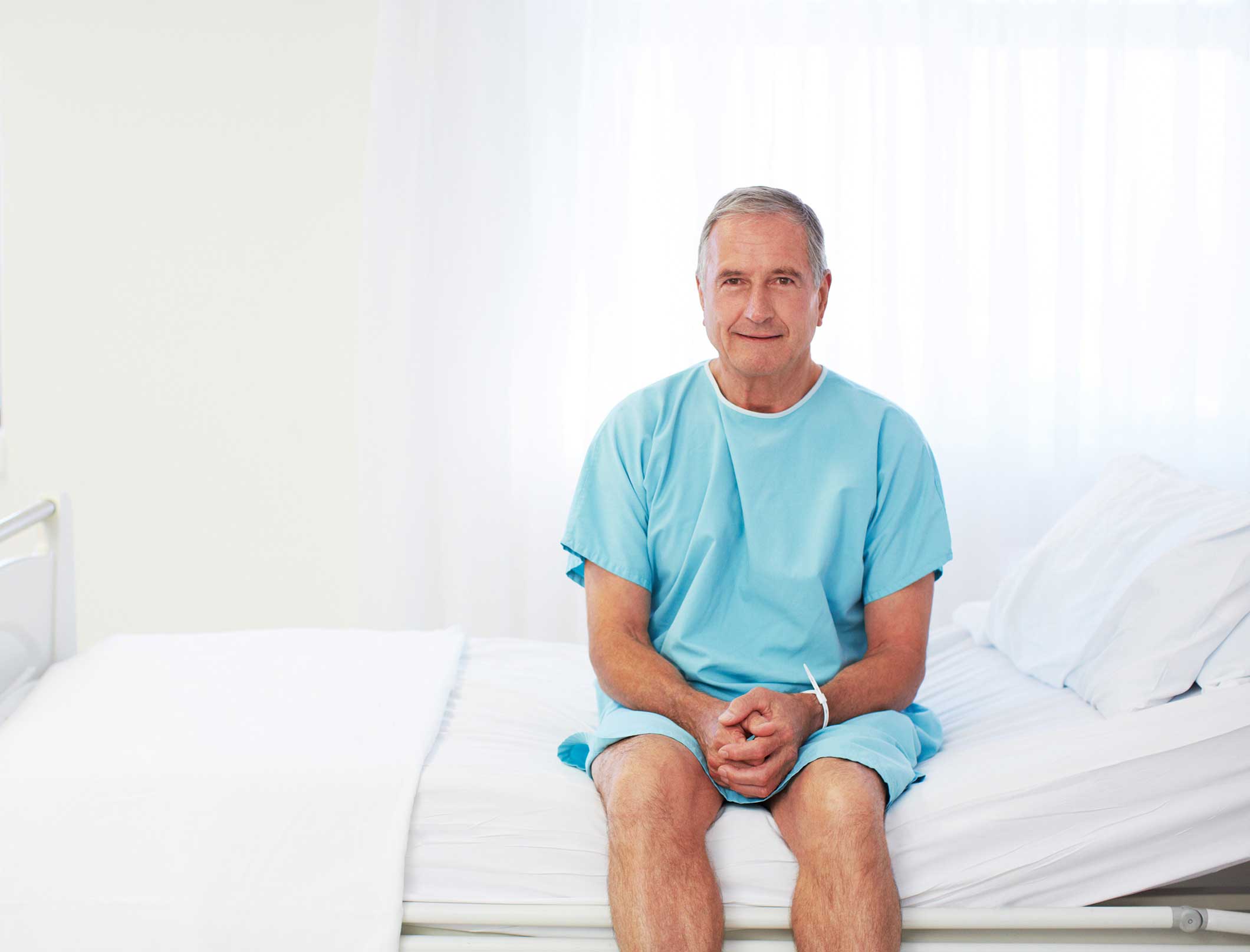 Senior man sitting on hospital bed